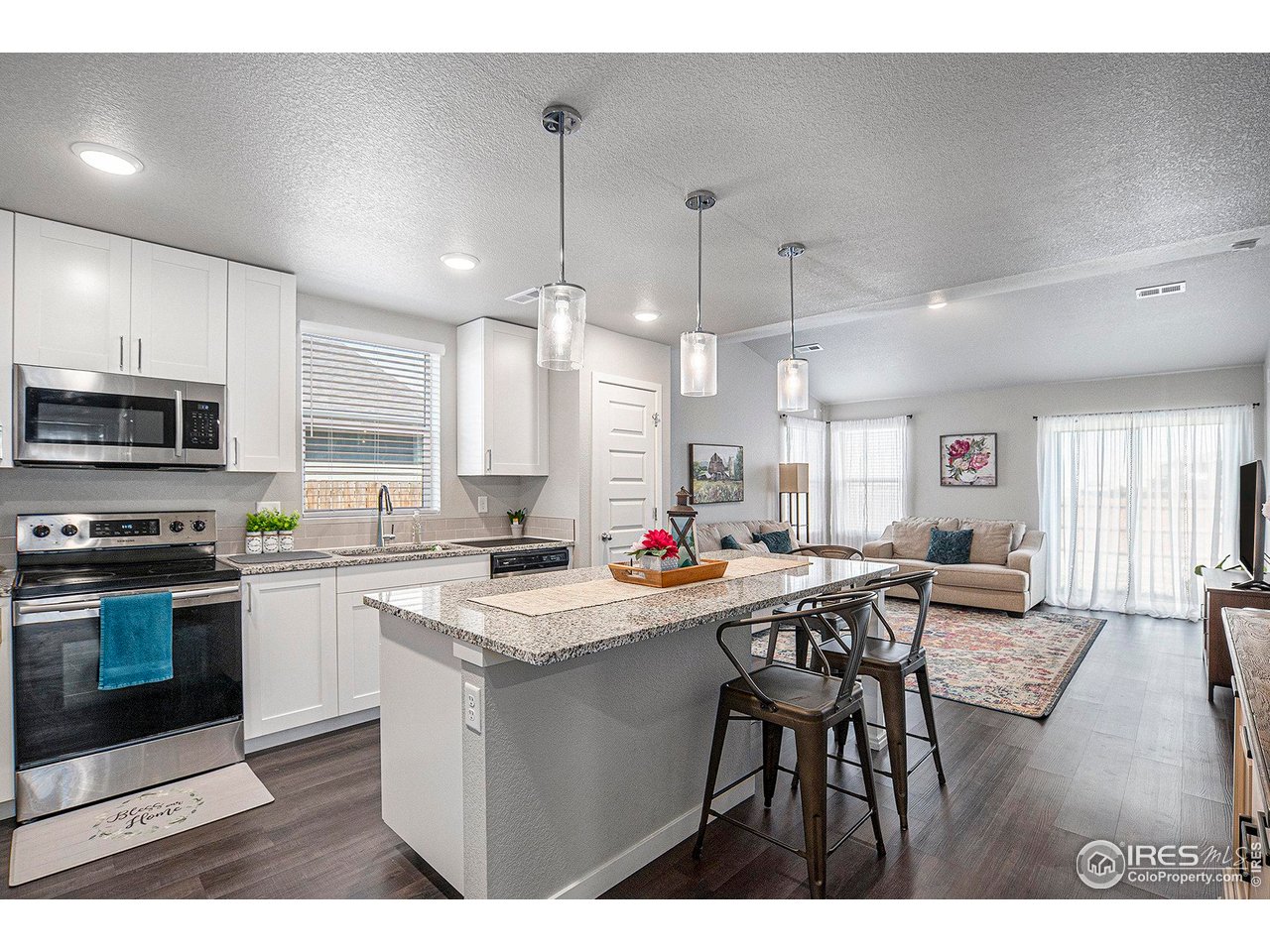 403 11th Avenue Wiggins, CO 80654 - Photo 4 of 13 a kitchen that has a table chairs microwave and cabinets