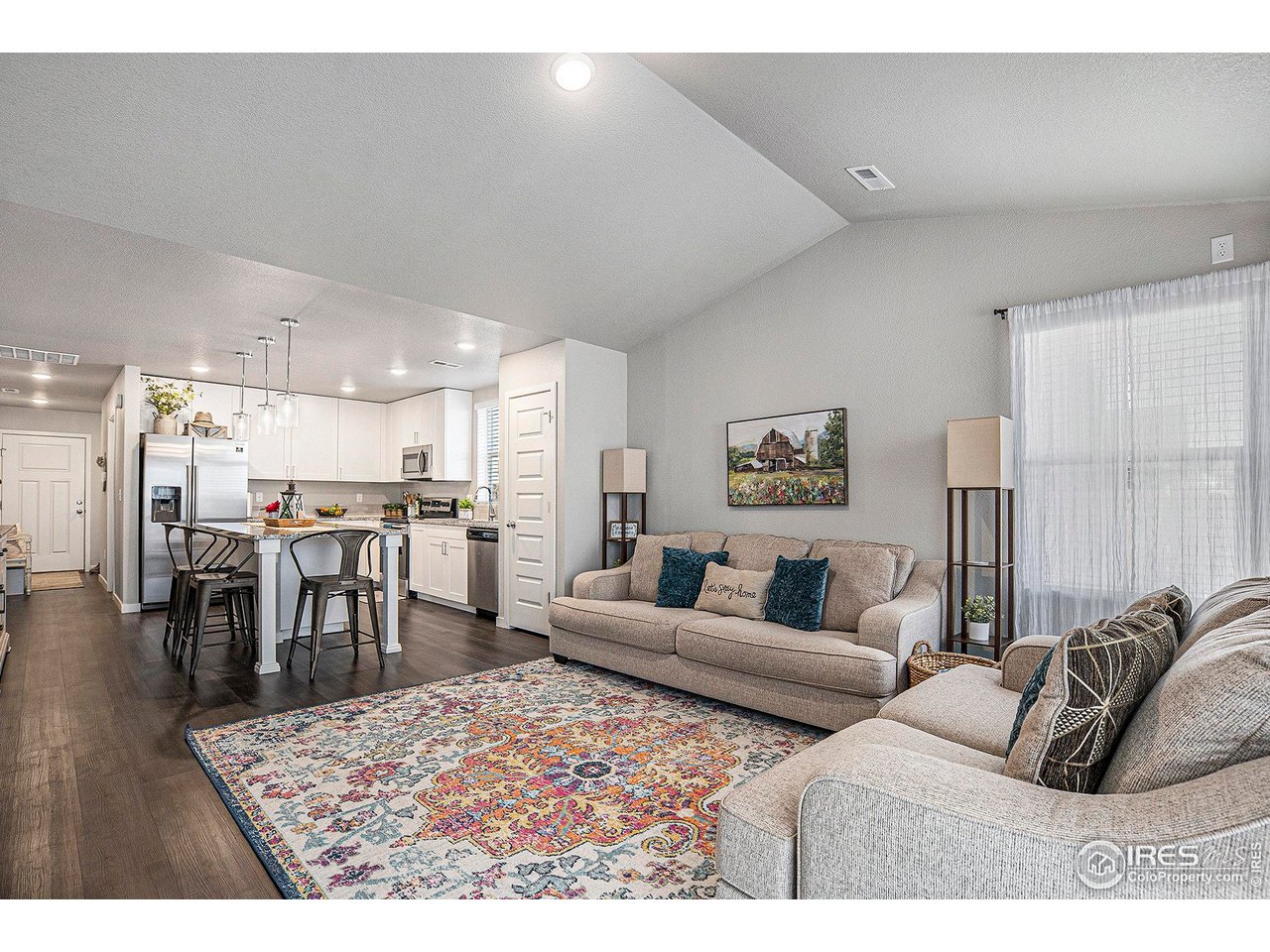 403 11th Avenue Wiggins, CO 80654 - Photo 7 of 13 a living room with furniture a wooden floor and kitchen view