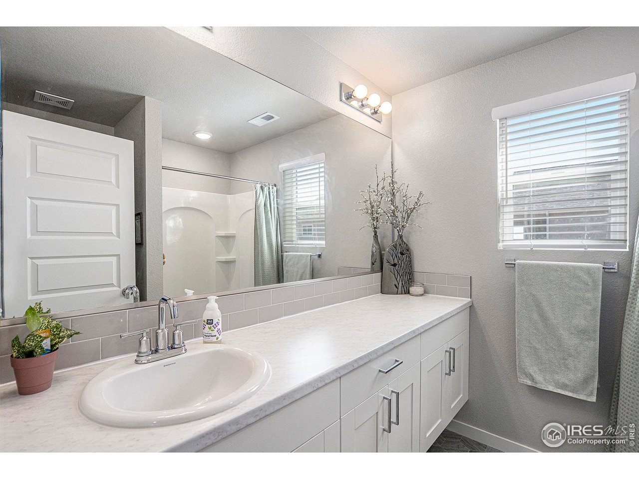 403 11th Avenue Wiggins, CO 80654 - Photo 9 of 13 a bathroom with a sink double vanity granite and a mirror