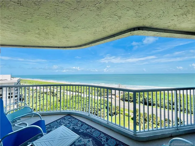 a view of a balcony with wooden floor & fence