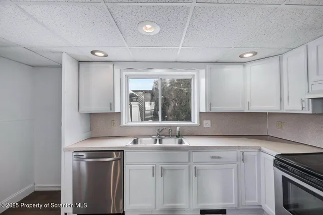 a kitchen with stainless steel appliances granite countertop a sink stove and cabinets