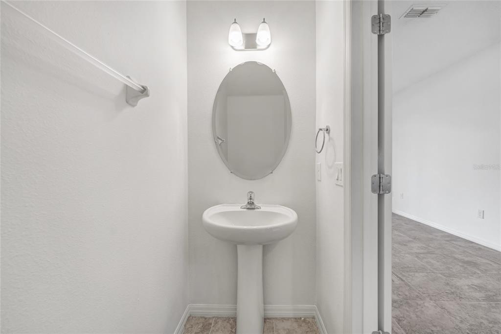 4824 Poolside Drive St. Cloud, FL 34769 - Photo 11 of 29 a bathroom with a sink a mirror and a light fixture