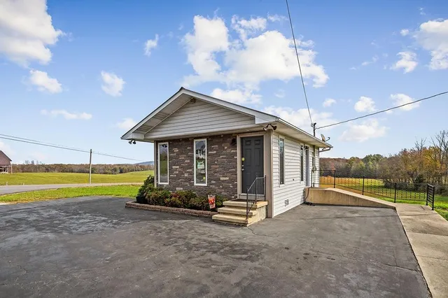 a view of a house with a yard and sitting area