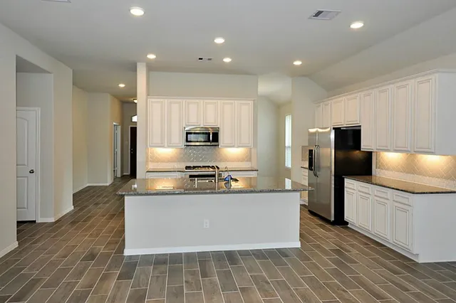 a view of an empty room with a fireplace and a window