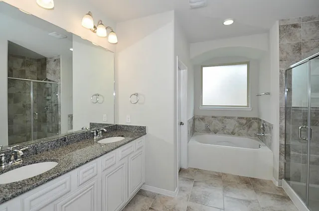 a large kitchen with stainless steel appliances a large counter top and wooden floors