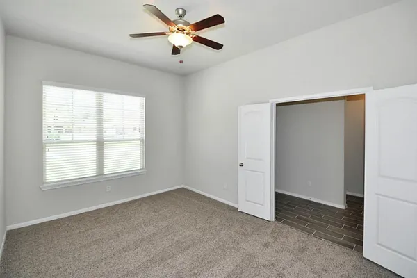 an empty room with a window and a fan