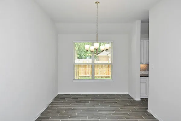 a view of a hallway with wooden floor and a living room