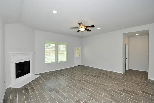a view of a room with a chandelier fan and kitchen view