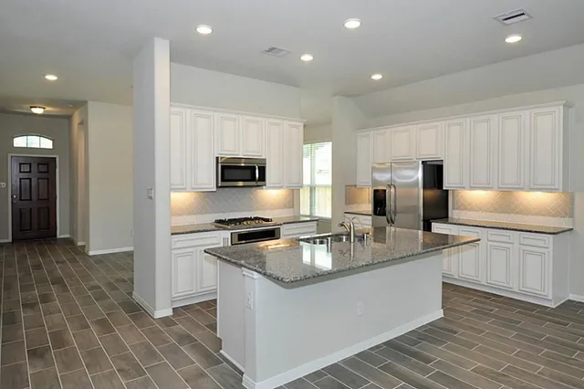 a view of kitchen with refrigerator stove and microwave