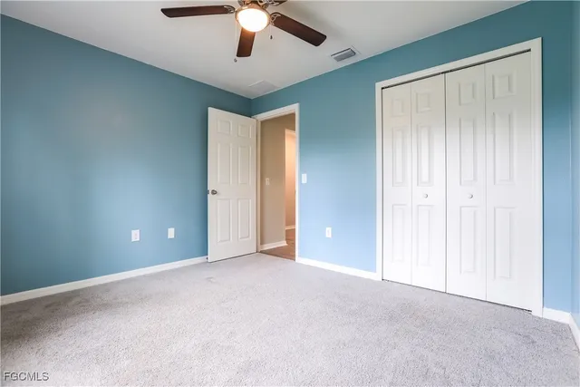an empty room with chandelier fan