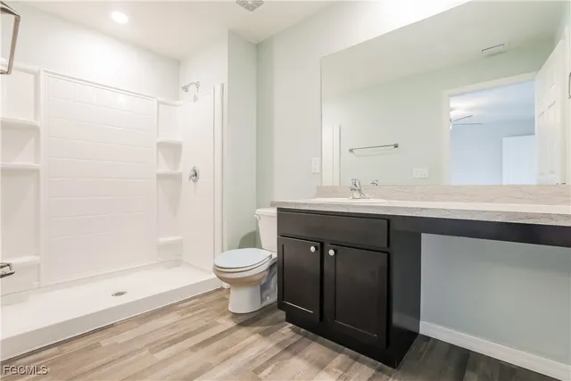 a bathroom with a sink a toilet a mirror and shower