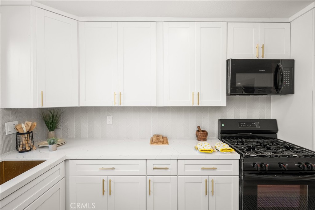 19212 Gunlock Avenue Carson, CA 90746 - Photo 20 of 56 a kitchen with stainless steel appliances white cabinets and a stove top oven