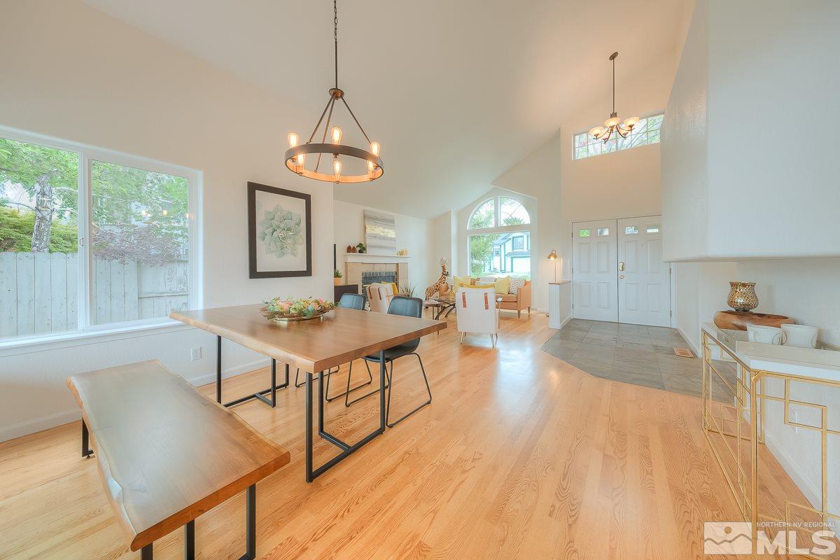 2688 Starr Meadows Loop Reno, NV 89519 - Photo 4 of 27 a living room with dining table wooden floor and a chandelier