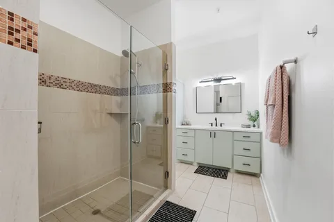 a bathroom with a shower sink and mirror
