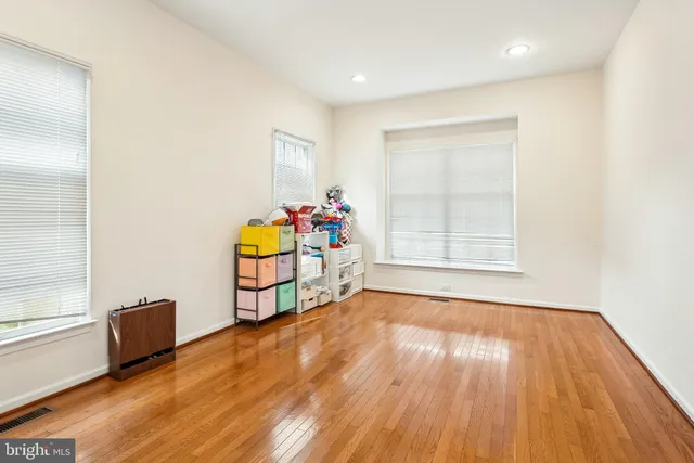 a view of an empty room with window and wooden floor