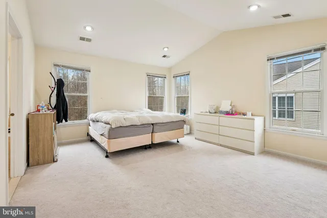 a spacious bedroom with a bed and a large window