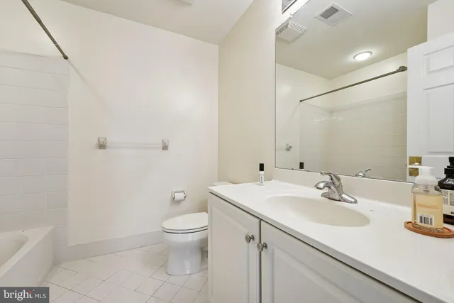 a bathroom with a sink a toilet and a large mirror