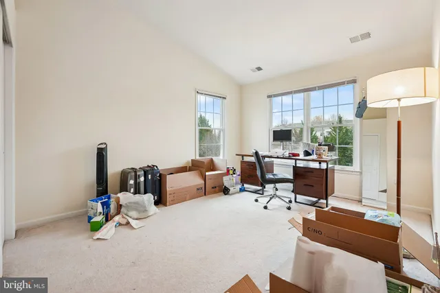 a living room with furniture and a refrigerator