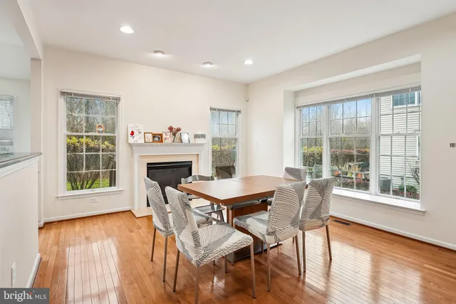 a dining room with furniture a fireplace and wooden floor