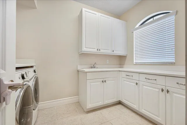 a view of a white house with a big yard and palm trees