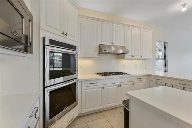 a kitchen with cabinets stainless steel appliances and sink
