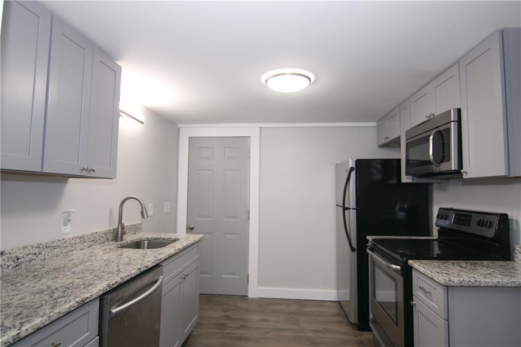 2187 Plantation Lane, Unit B Chamblee, GA 30341 - Photo 2 of 25 a kitchen with stainless steel appliances granite countertop a sink stove and refrigerator