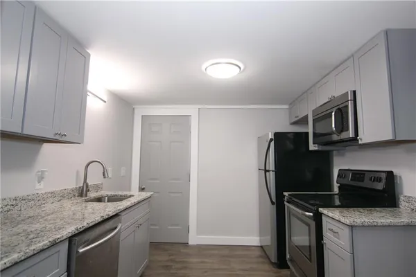 a kitchen with stainless steel appliances granite countertop a refrigerator sink and stove