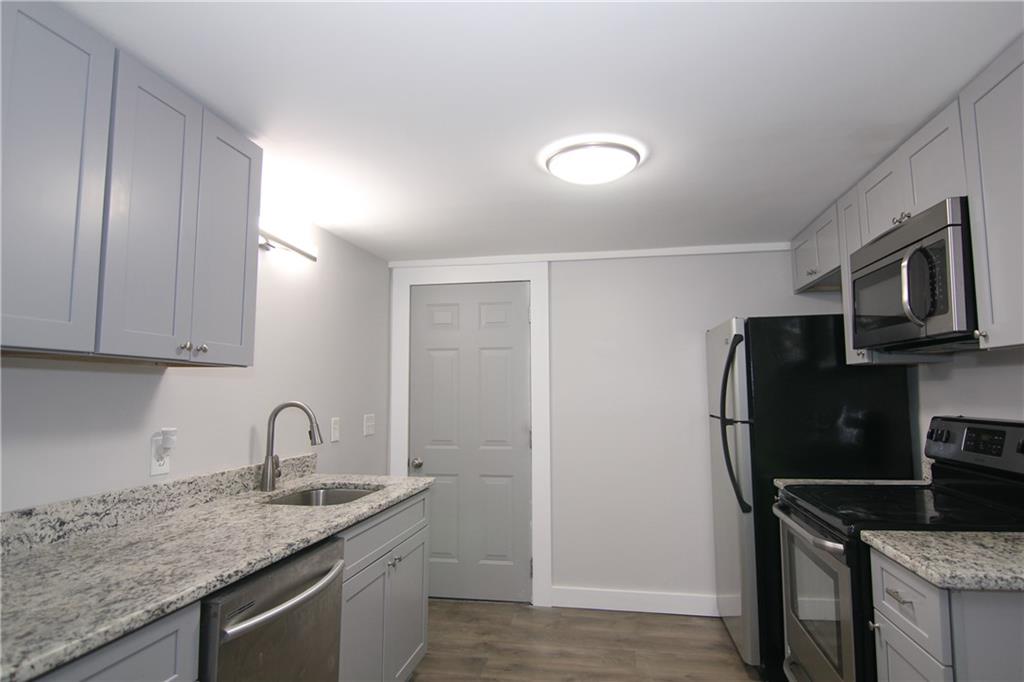 2187 Plantation Lane, Unit B Chamblee, GA 30341 - Photo 4 of 25 a kitchen with stainless steel appliances granite countertop a sink stove and refrigerator