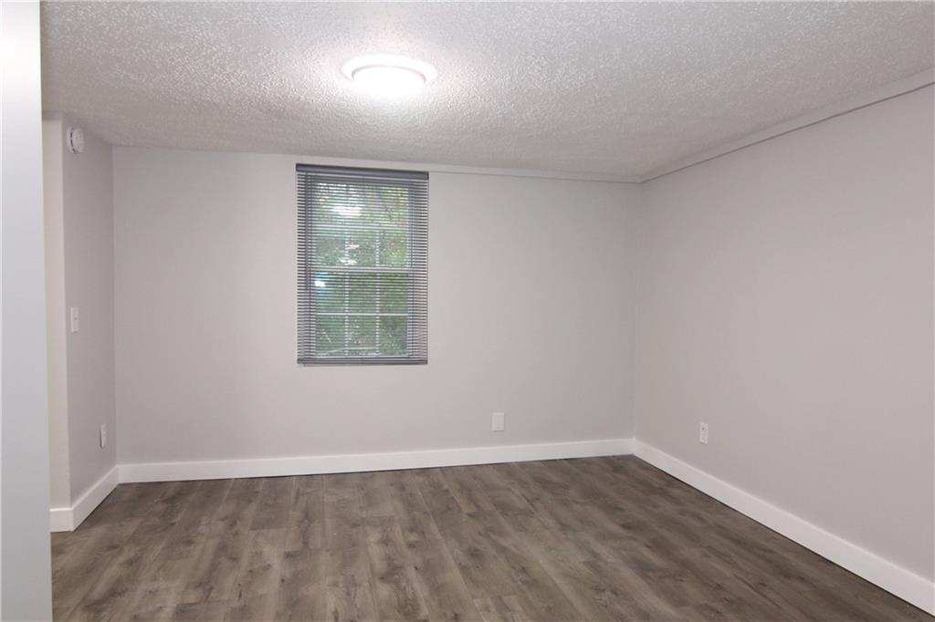 2187 Plantation Lane, Unit B Chamblee, GA 30341 - Photo 9 of 25 a view of an empty room with wooden floor and a window