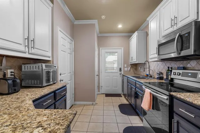 a kitchen with stainless steel appliances granite countertop a stove microwave and cabinets