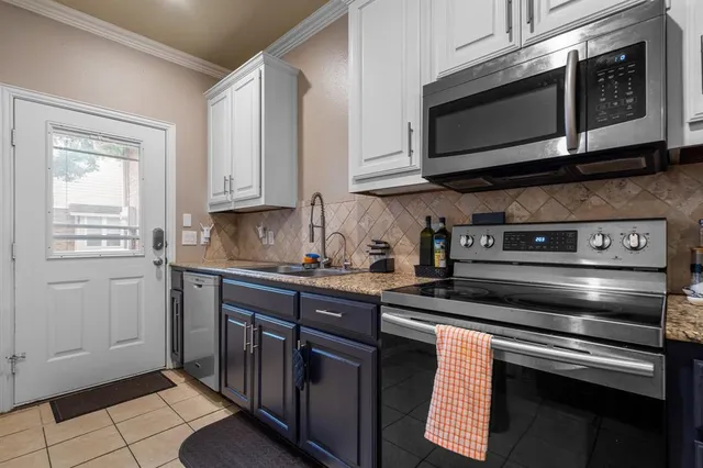 a kitchen with stainless steel appliances granite countertop a refrigerator a stove top oven a sink dishwasher and wooden cabinets