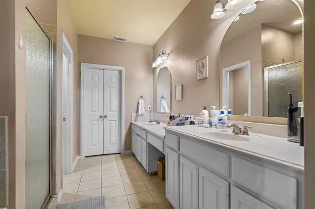 a en suite bathroom with a granite countertop sink a mirror and a bathtub