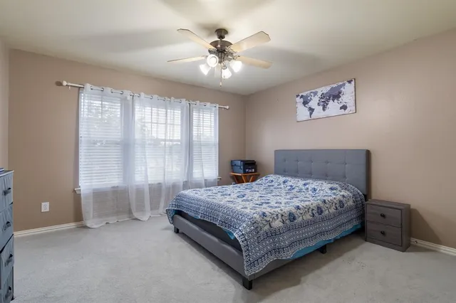 a bedroom with a large bed and a chandelier