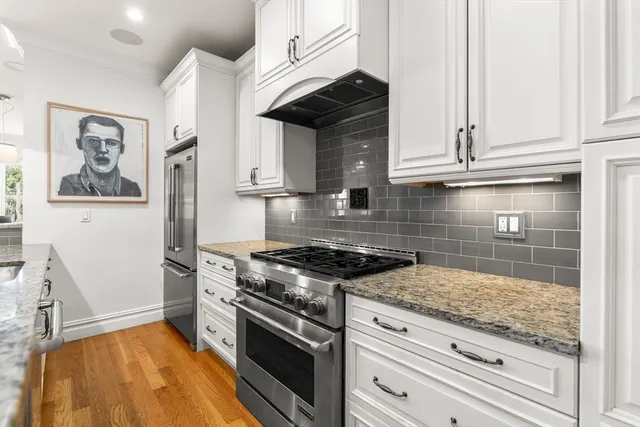 a kitchen with granite countertop stainless steel appliances and white cabinets