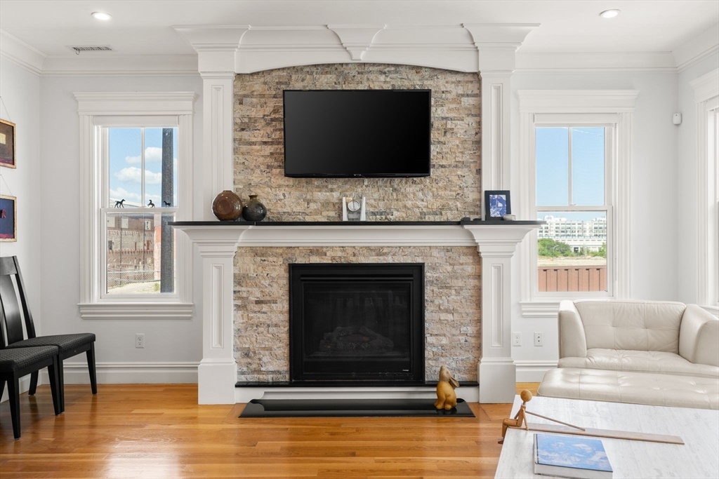 3 M Street, Unit 3 Boston, MA 02127 - Photo 3 of 34 a living room with a fireplace a flat screen tv and a window