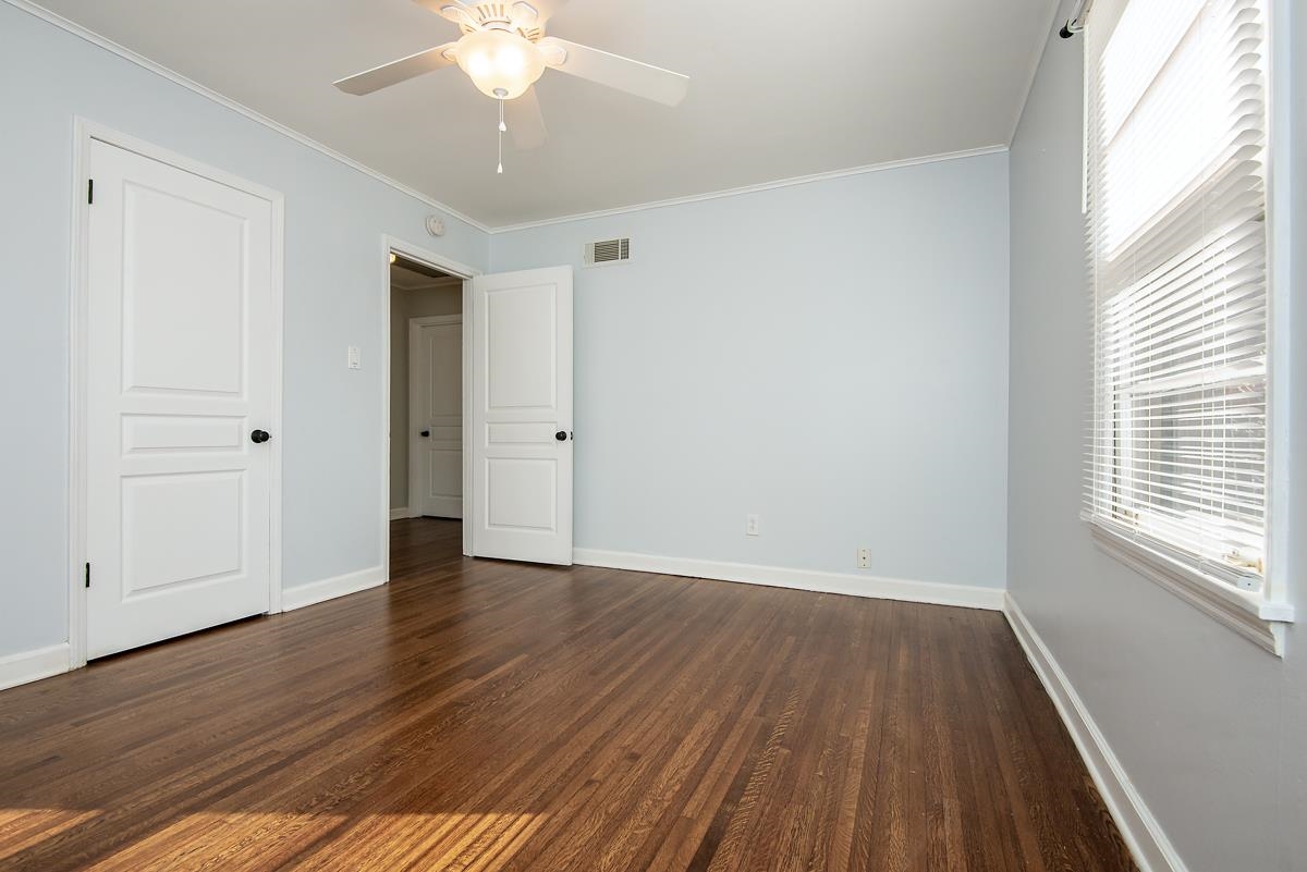 4628 Boyce Road Memphis, TN 38117 - Photo 13 of 25 an empty room with wooden floor and windows