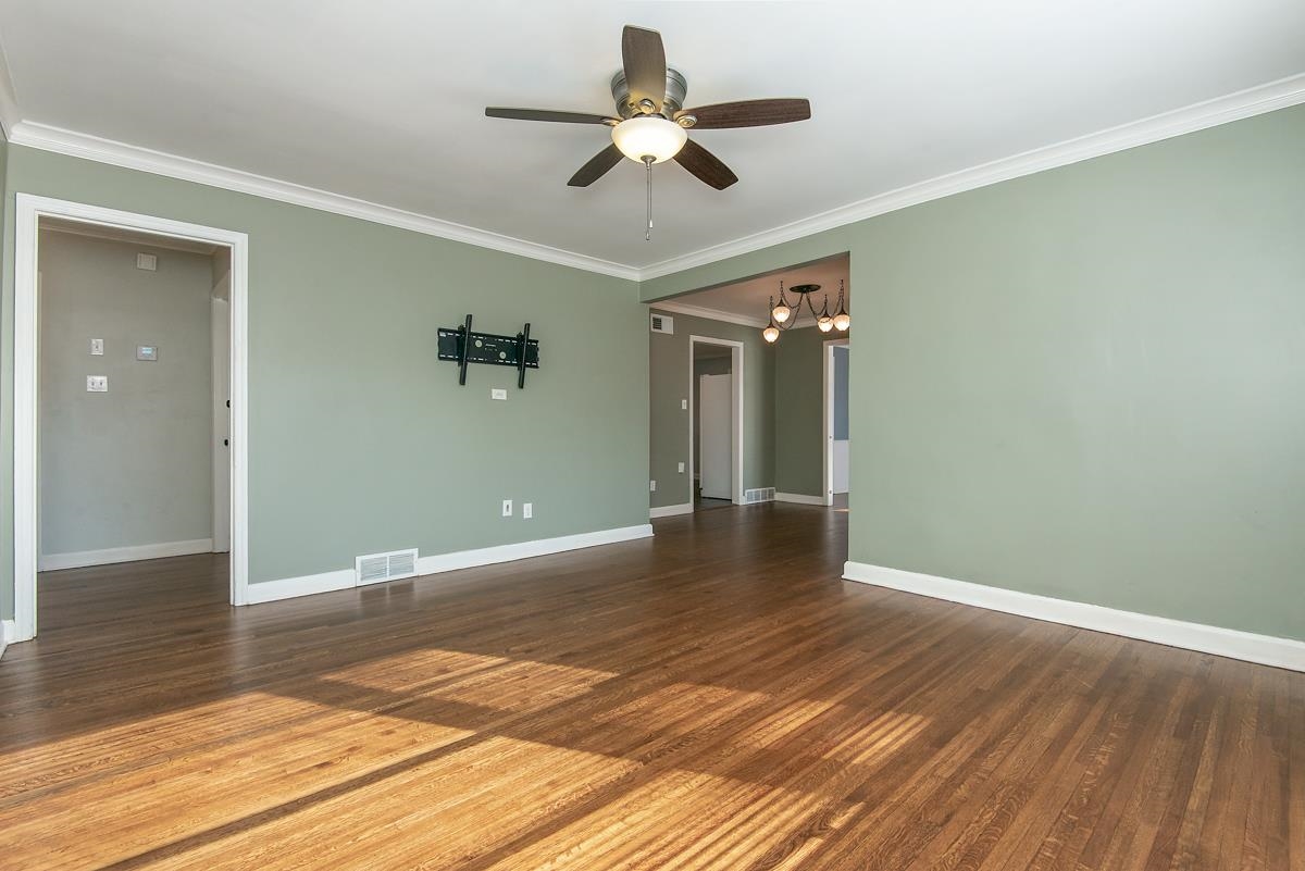 4628 Boyce Road Memphis, TN 38117 - Photo 4 of 25 wooden floor in an empty room with a chandelier fan