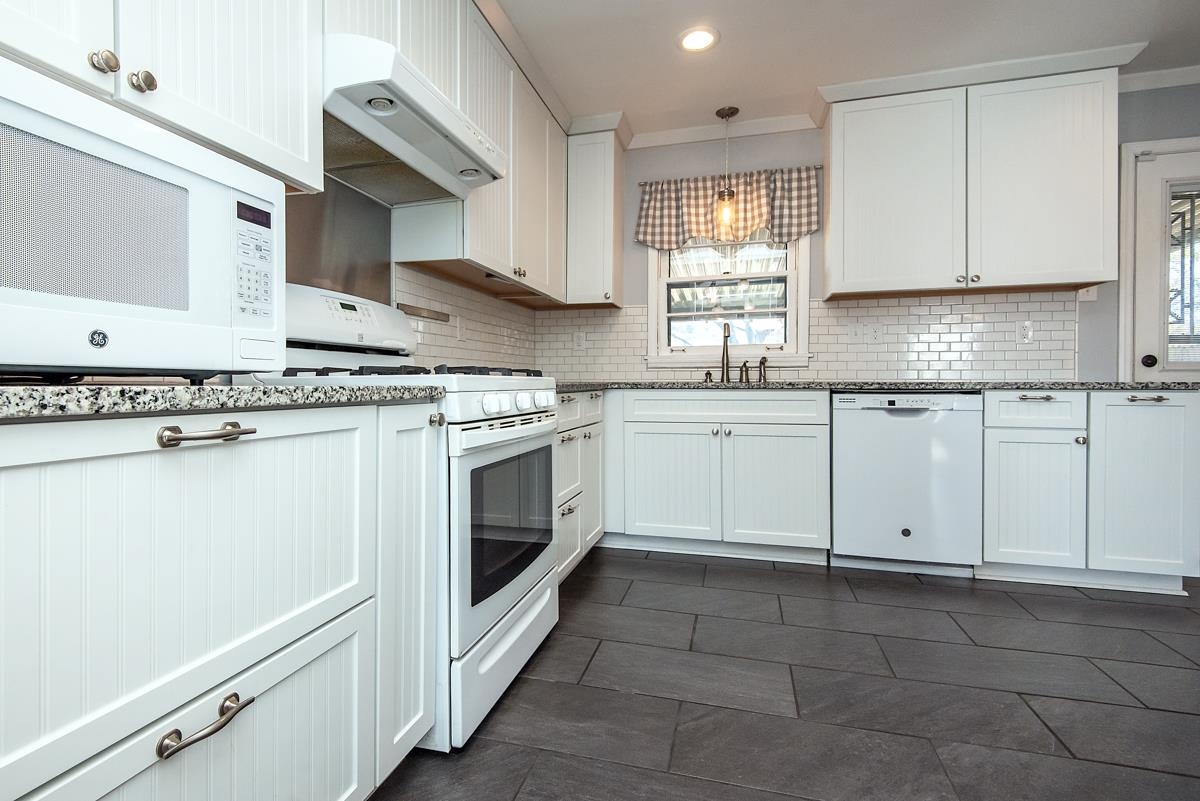 4628 Boyce Road Memphis, TN 38117 - Photo 5 of 25 a kitchen with granite countertop white cabinets and white appliances