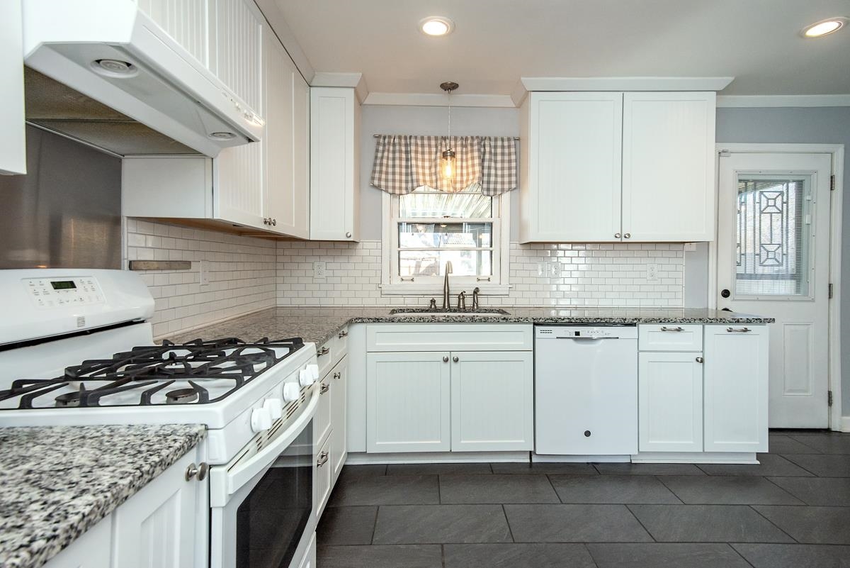 4628 Boyce Road Memphis, TN 38117 - Photo 7 of 25 a kitchen with granite countertop a sink a stove and cabinets