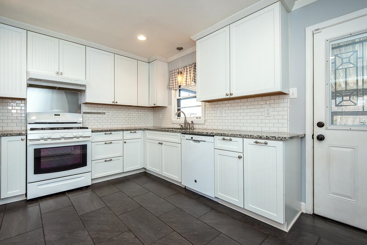 4628 Boyce Road Memphis, TN 38117 - Photo 9 of 25 a kitchen with granite countertop white cabinets and white appliances