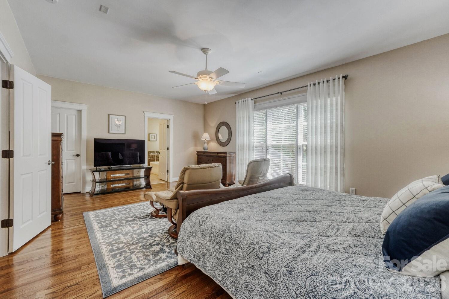 183 Lavender Bloom Loop Mooresville, NC 28115 - Photo 15 of 46 a bedroom with a bed wooden floor and a fireplace