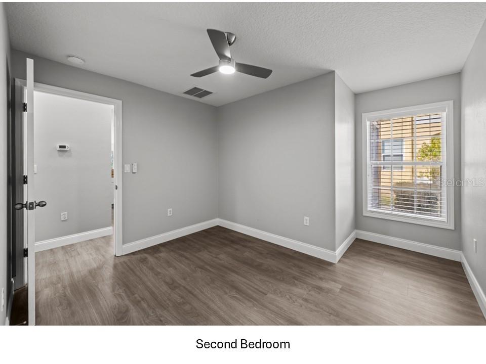 8516 Corinthian Way New Port Richey, FL 34654 - Photo 12 of 24 a living room with a wooden floor and a ceiling fan