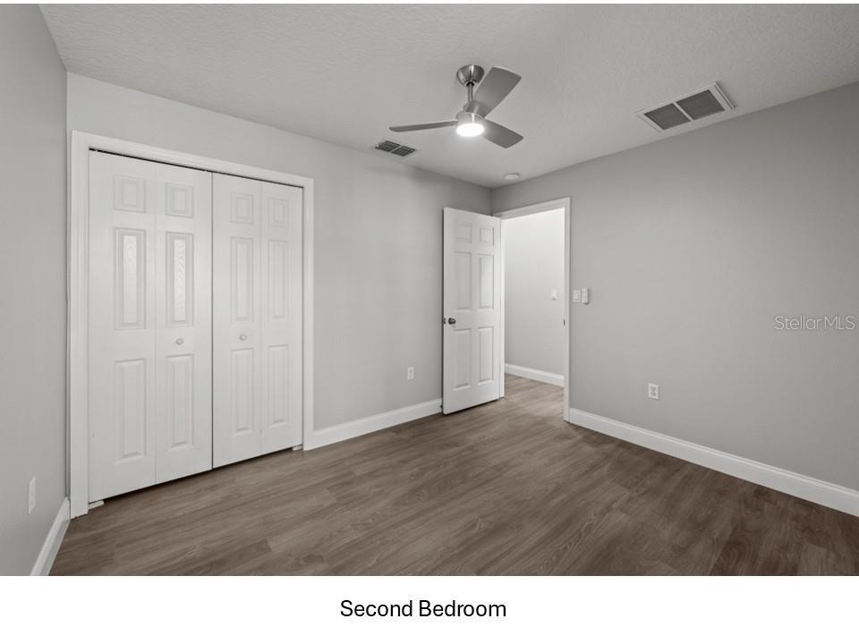 8516 Corinthian Way New Port Richey, FL 34654 - Photo 13 of 24 a black and white kitchen with wooden floor