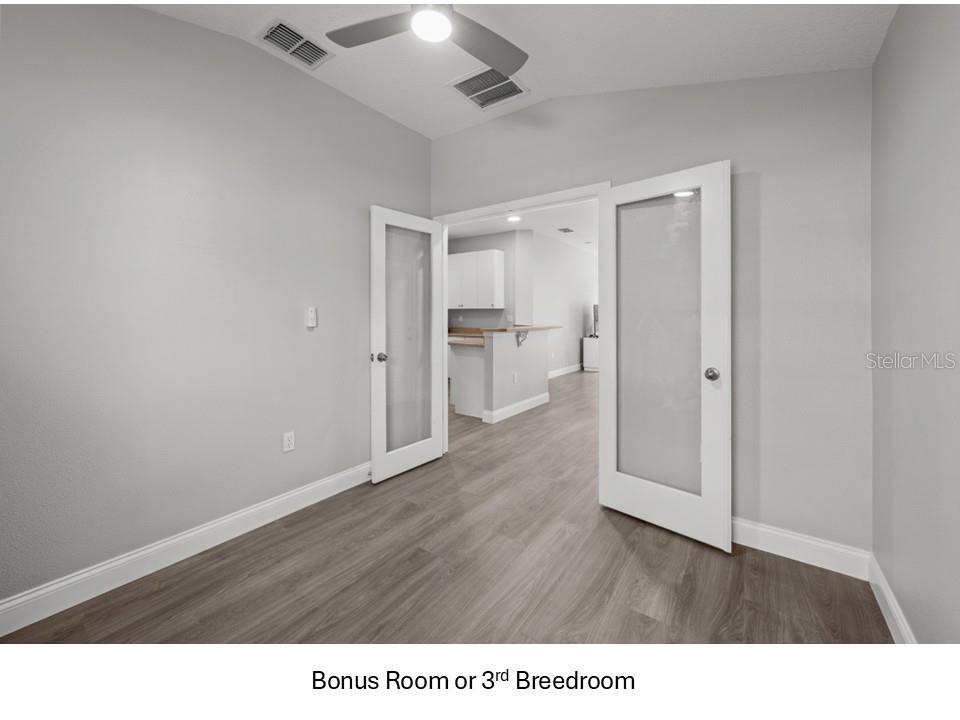 8516 Corinthian Way New Port Richey, FL 34654 - Photo 15 of 24 a room with wooden floor and a cabinet