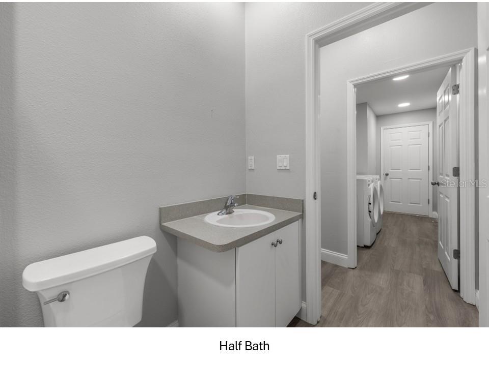 8516 Corinthian Way New Port Richey, FL 34654 - Photo 18 of 24 a bathroom with a sink a toilet a mirror and vanity