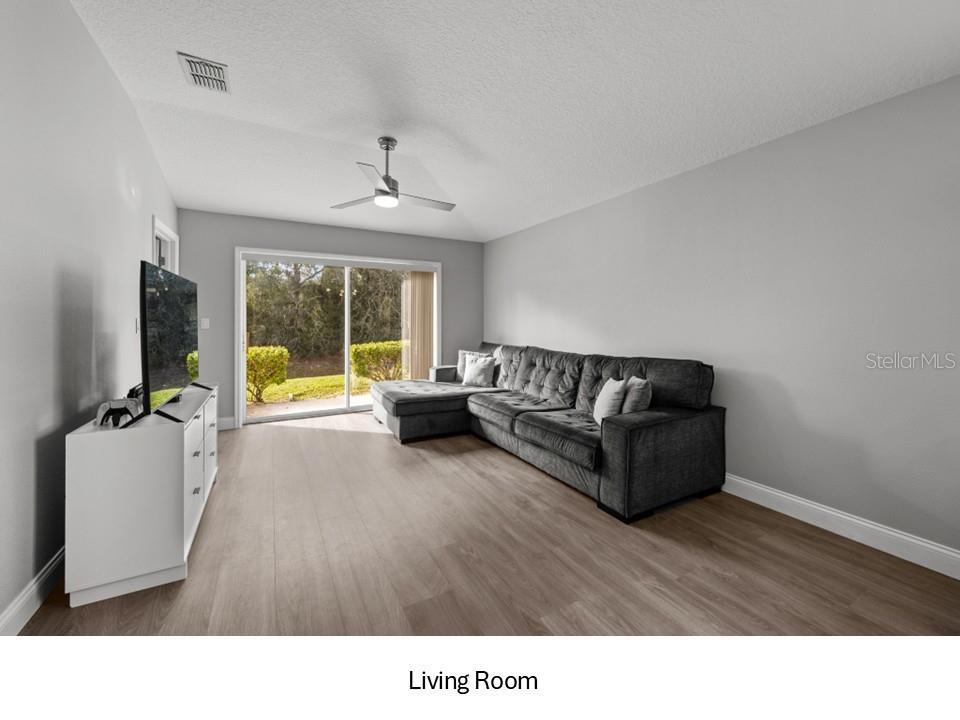 8516 Corinthian Way New Port Richey, FL 34654 - Photo 5 of 24 a living room with furniture and a large window