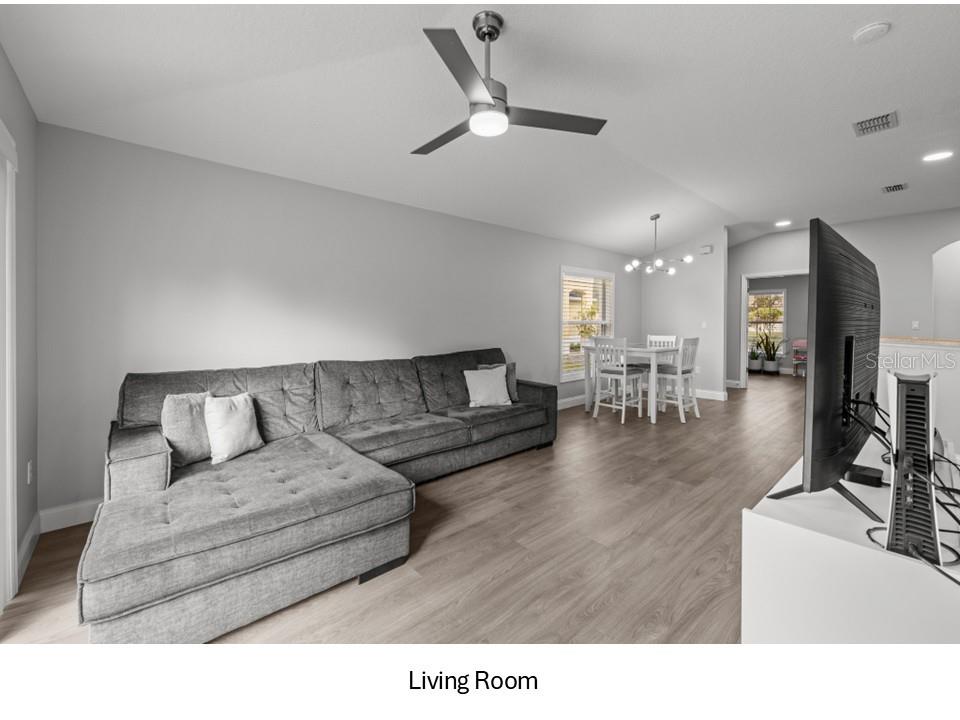 8516 Corinthian Way New Port Richey, FL 34654 - Photo 6 of 24 a living room with furniture and a dining table with wooden floor