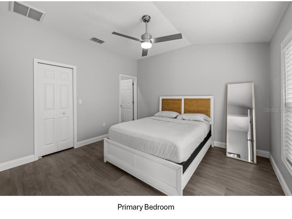 8516 Corinthian Way New Port Richey, FL 34654 - Photo 8 of 24 a bedroom with a bed and wooden floor