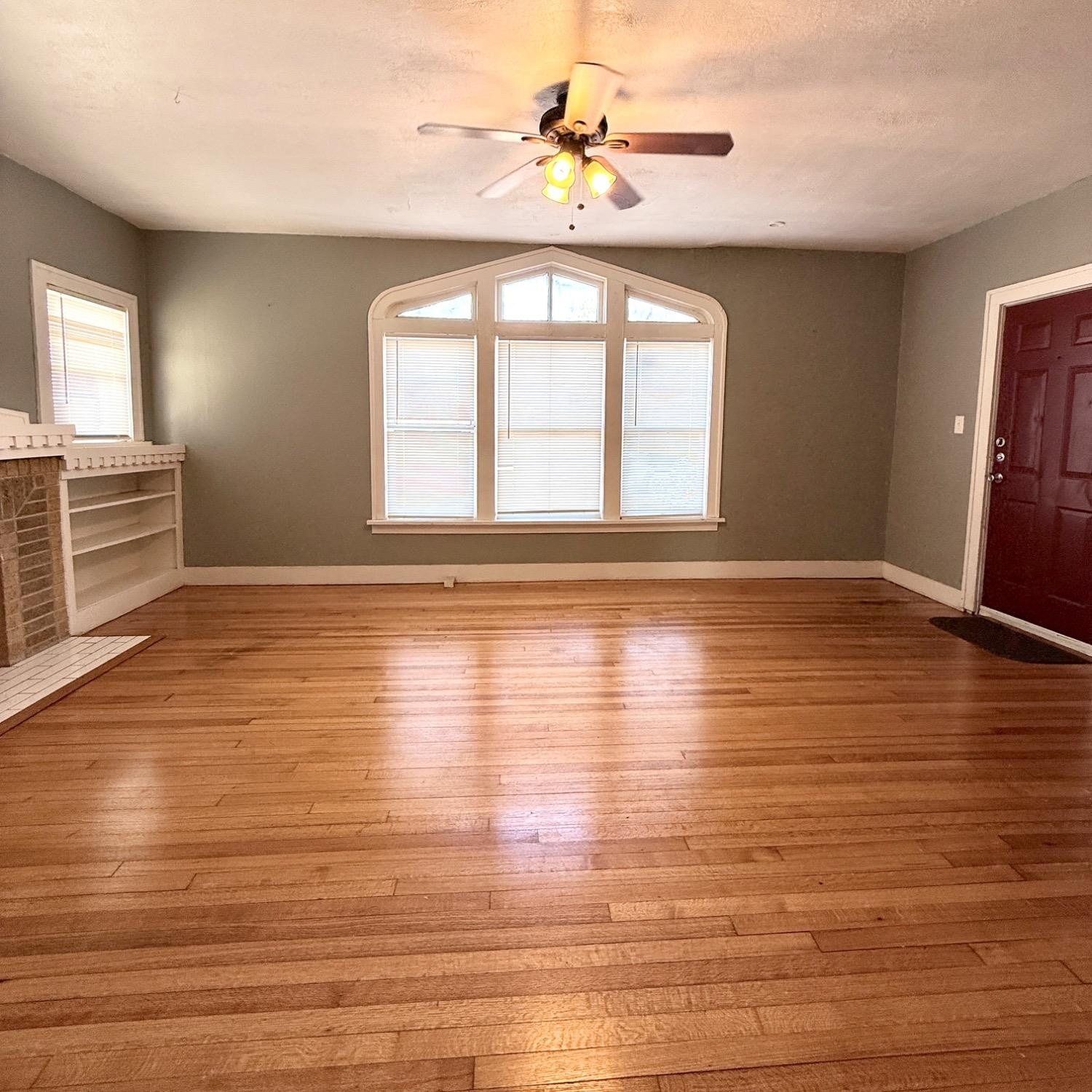 2105 14th Street, Unit 1 Lubbock, TX 79401 - Photo 5 of 11 a view of an empty room with window and wooden floor