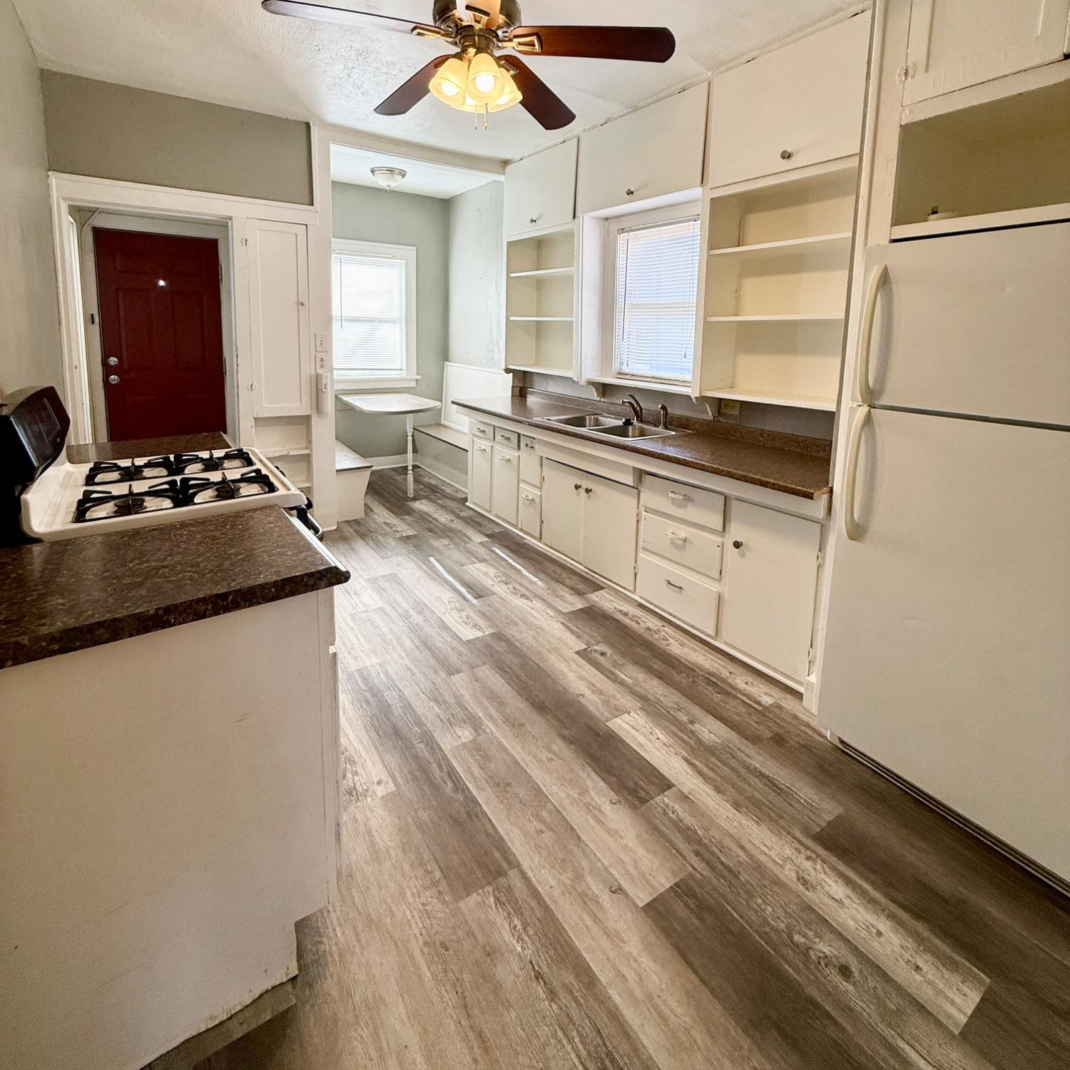 2105 14th Street, Unit 1 Lubbock, TX 79401 - Photo 8 of 11 a kitchen with kitchen island granite countertop a stove and a refrigerator